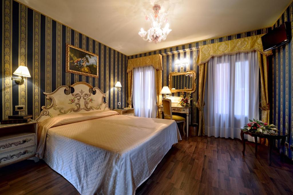 1 dormitorio con cama y lámpara de araña en Hotel Città Di Milano en Venecia