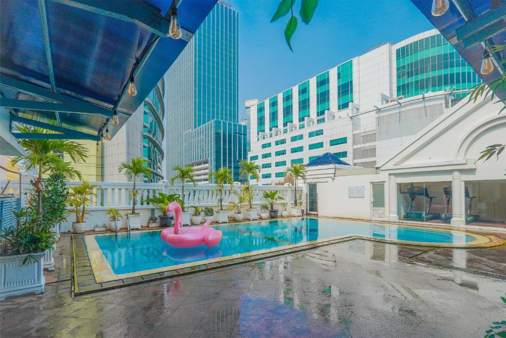 a pool with a pink swan in the middle of a building at Ambhara Hotel Jakarta in Jakarta