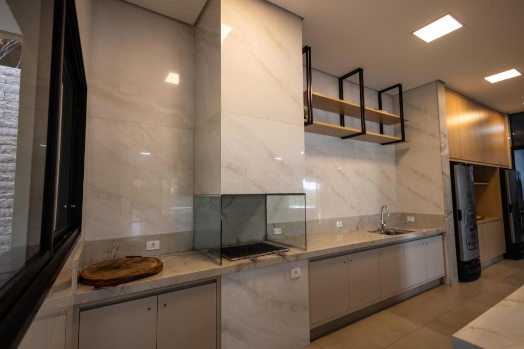 a large kitchen with a counter and a sink at Espaço JF in Aparecida de Goiânia