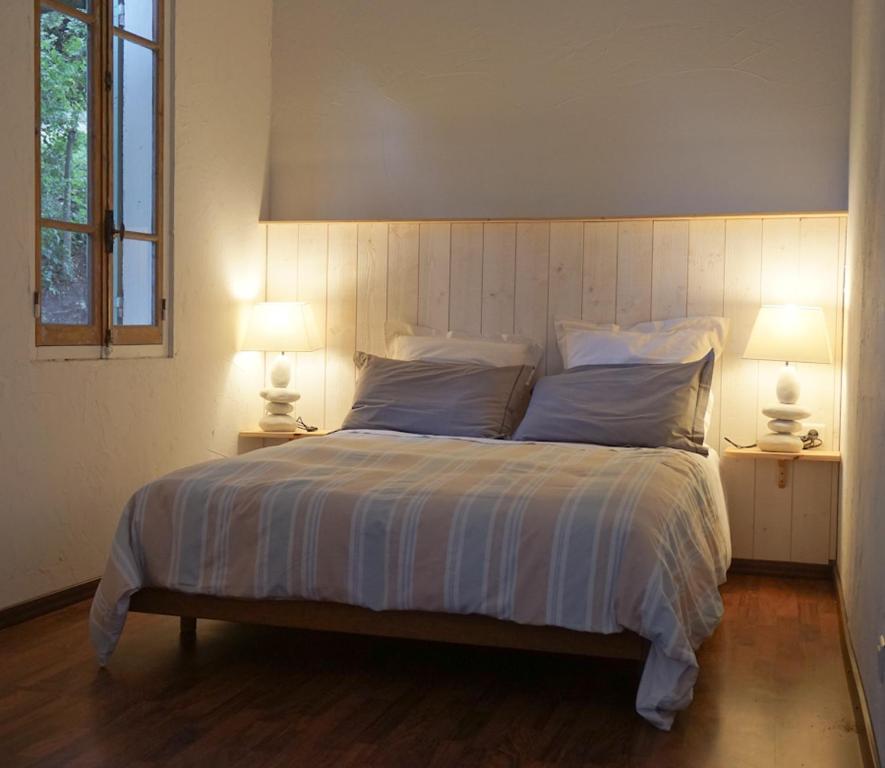 um quarto com uma cama grande e 2 candeeiros em La Petite Maison em Villeneuve-lès-Avignon