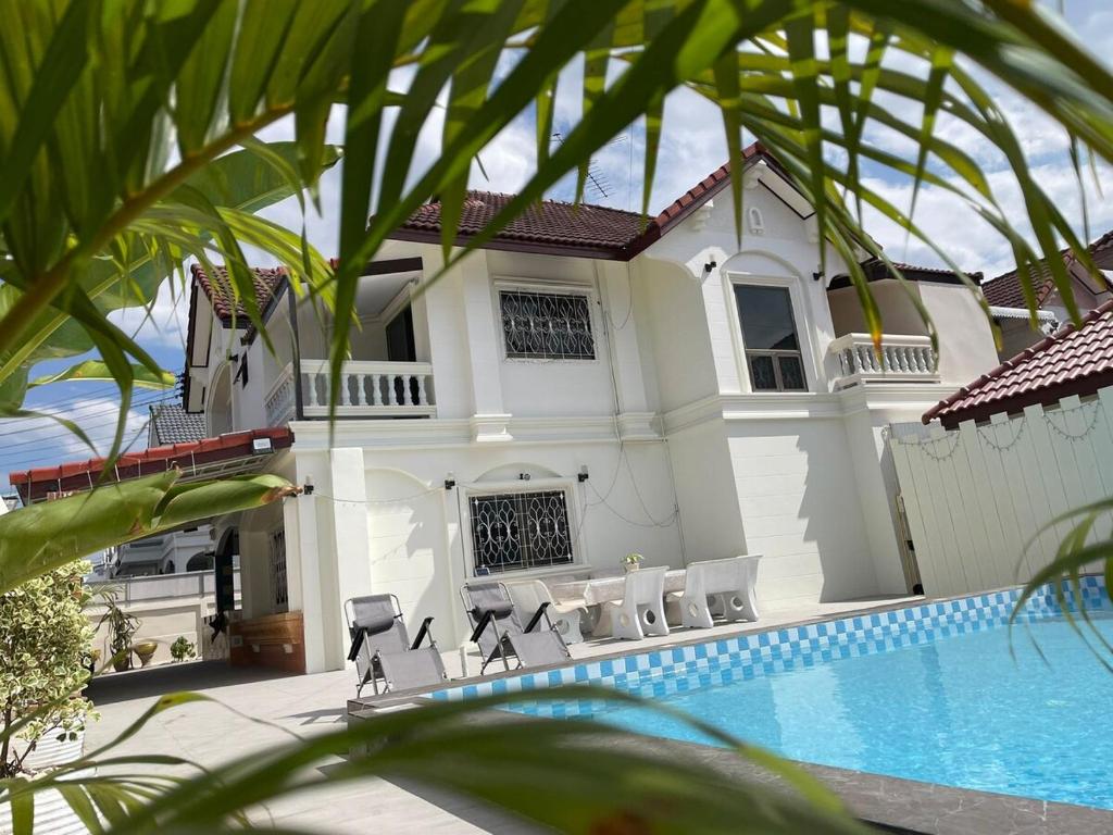 a villa with a swimming pool in front of a house at 5BR Private Pool in Jomtien Beach