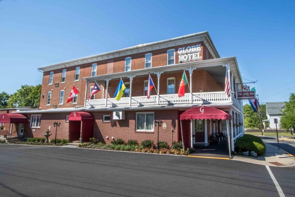 un hôtel au coin d'une rue arborant des drapeaux dans l'établissement The Globe Inn, à East Greenville