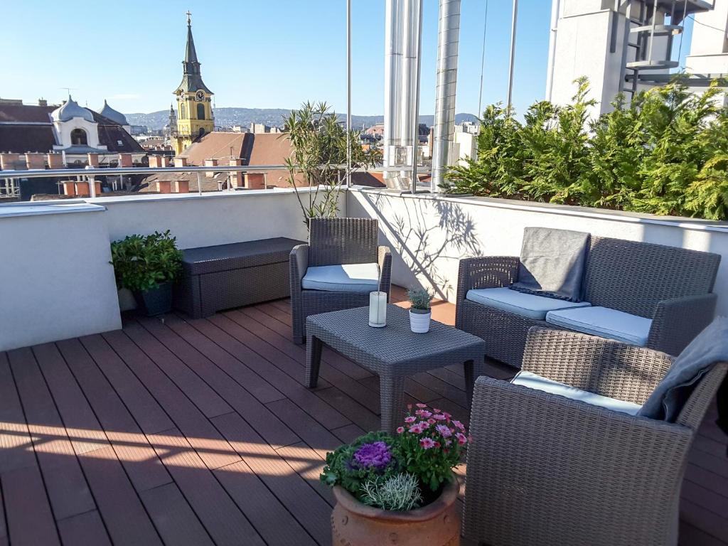 a patio with chairs and tables on a balcony at Bp Central Home in Budapest