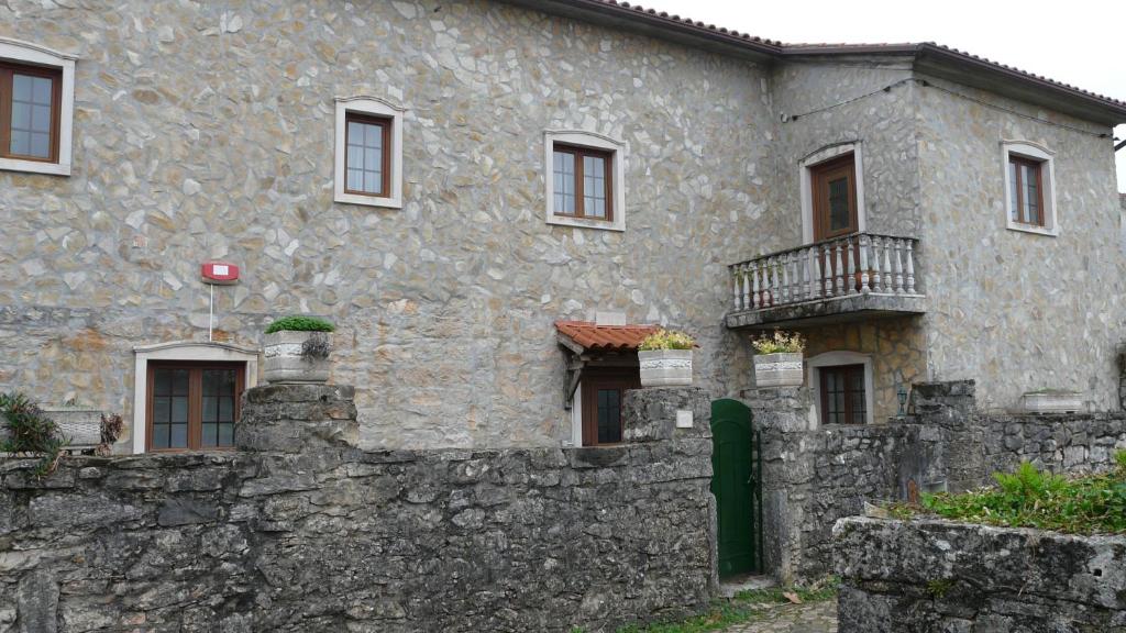a large stone building with a stone wall at Casa Vale Florido in Alvorge