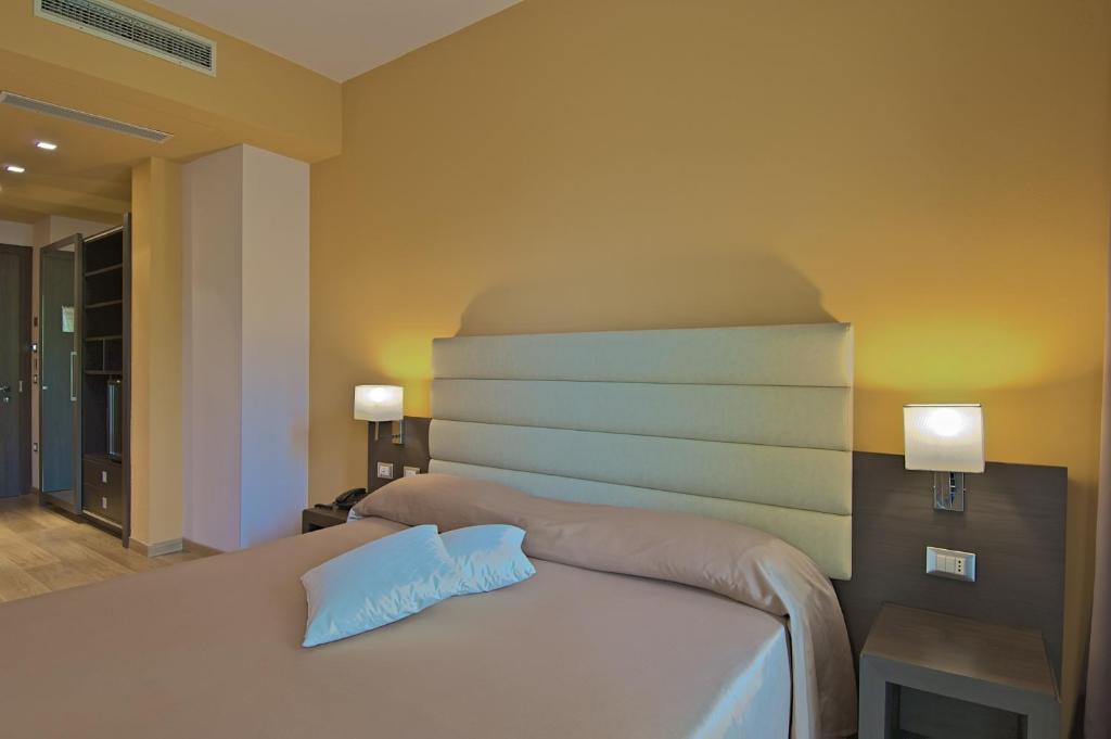 a bedroom with a bed with two pillows on it at Zen Hotel Versilia in Marina di Pietrasanta