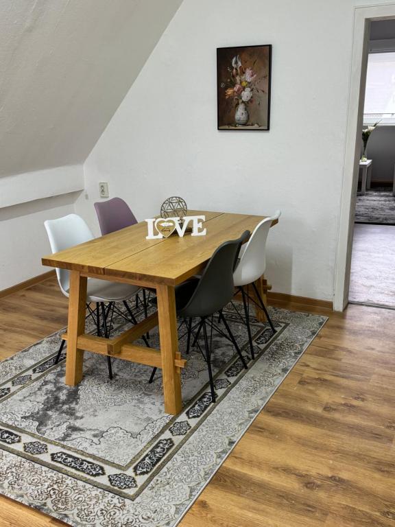 a dining room table with white chairs and a wooden table at Schelder Unterkunft in Dillenburg