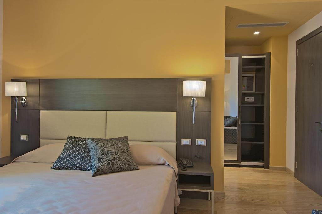 a bedroom with a large bed with a wooden headboard at Zen Hotel Versilia in Marina di Pietrasanta