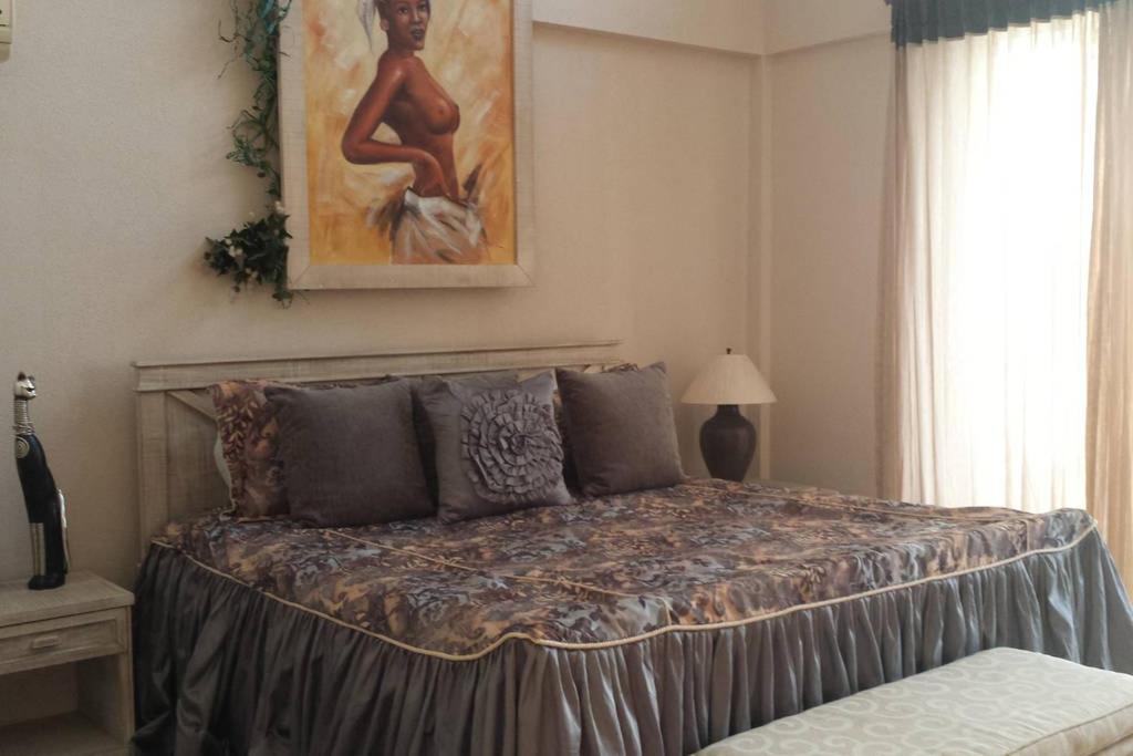 1 dormitorio con 1 cama con una pintura en la pared en Ocean Front Two Bedroom Penthouse, en Sosúa