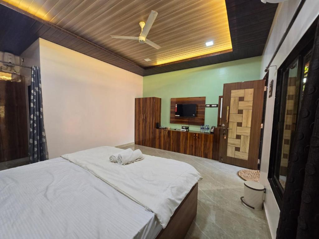 a bedroom with a bed with a ceiling fan at Private Beach - Exotic Sea View Resort in Ganpatipule