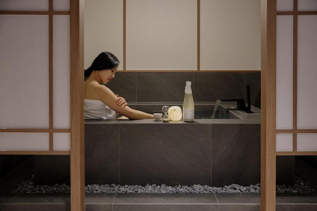 Eine Frau sitzt in einem Spülbecken in der Küche. in der Unterkunft Hotel Flow-er in Kangnŭng-yŏk