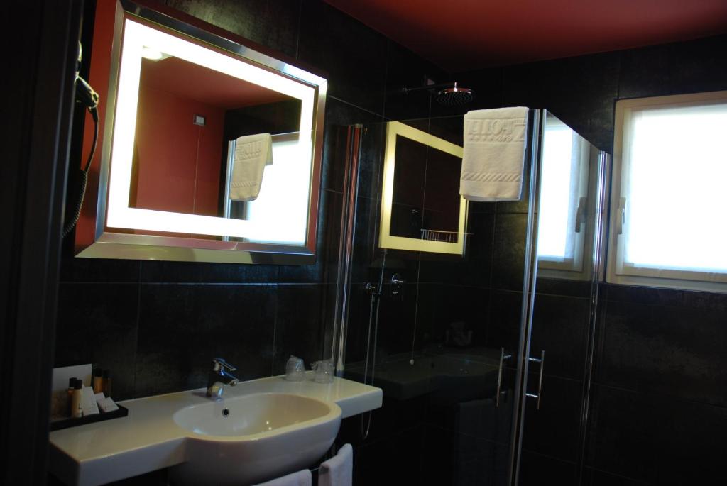 a bathroom with a sink and a shower and a mirror at Zen Hotel Versilia in Marina di Pietrasanta