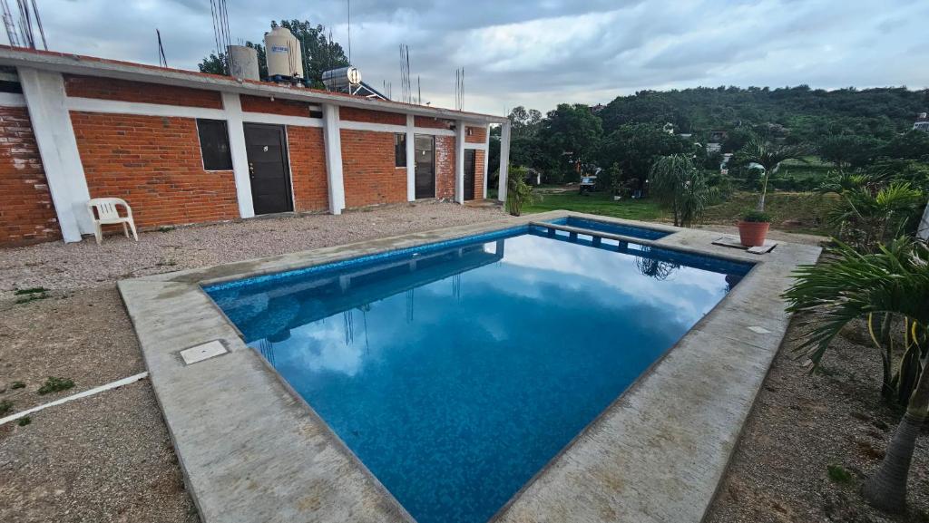 a swimming pool in front of a house at Hospedaje Tecmilco in Tepoztlán