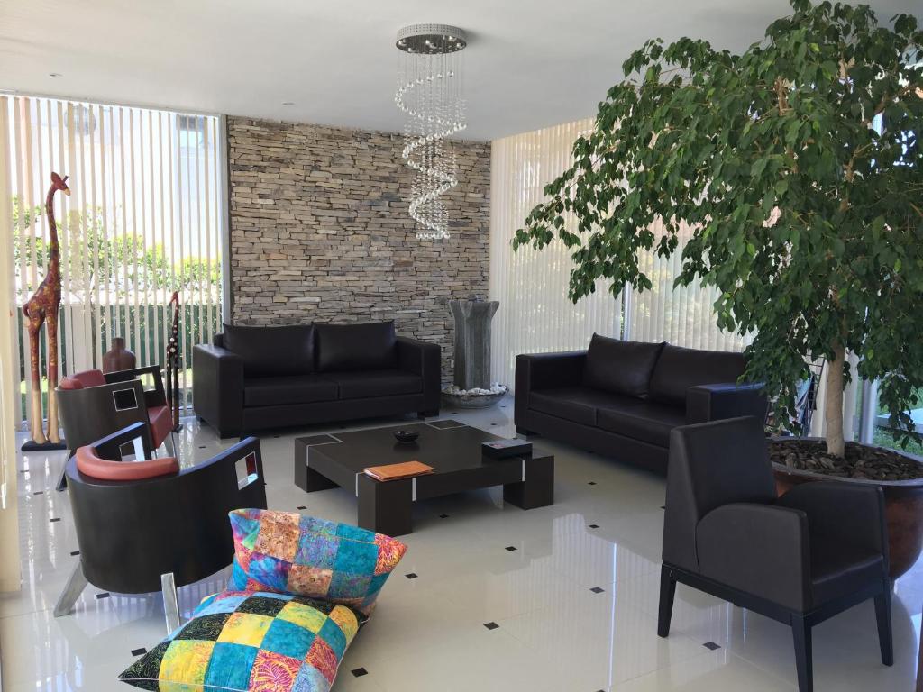 een woonkamer met zwarte meubels en een boom bij La Mirage in Villa Gesell