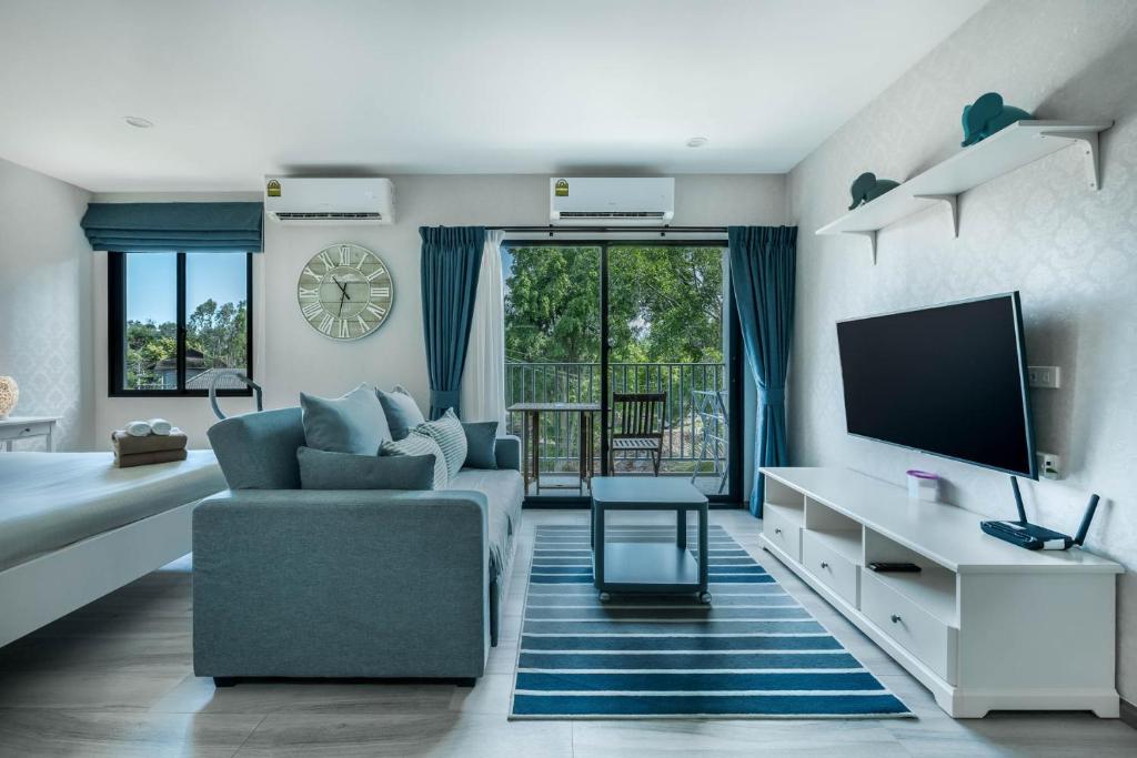 a living room with a couch and a tv at Studio Apartment by the Sea E413 in Phuket
