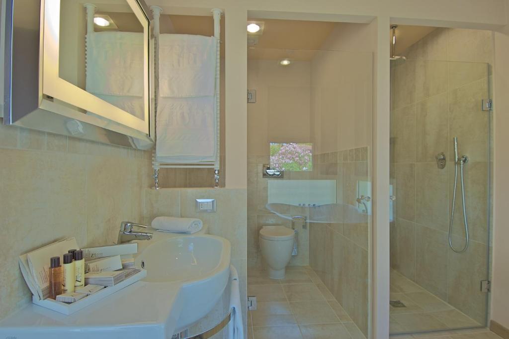 a bathroom with a sink and a shower and a toilet at Zen Hotel Versilia in Marina di Pietrasanta