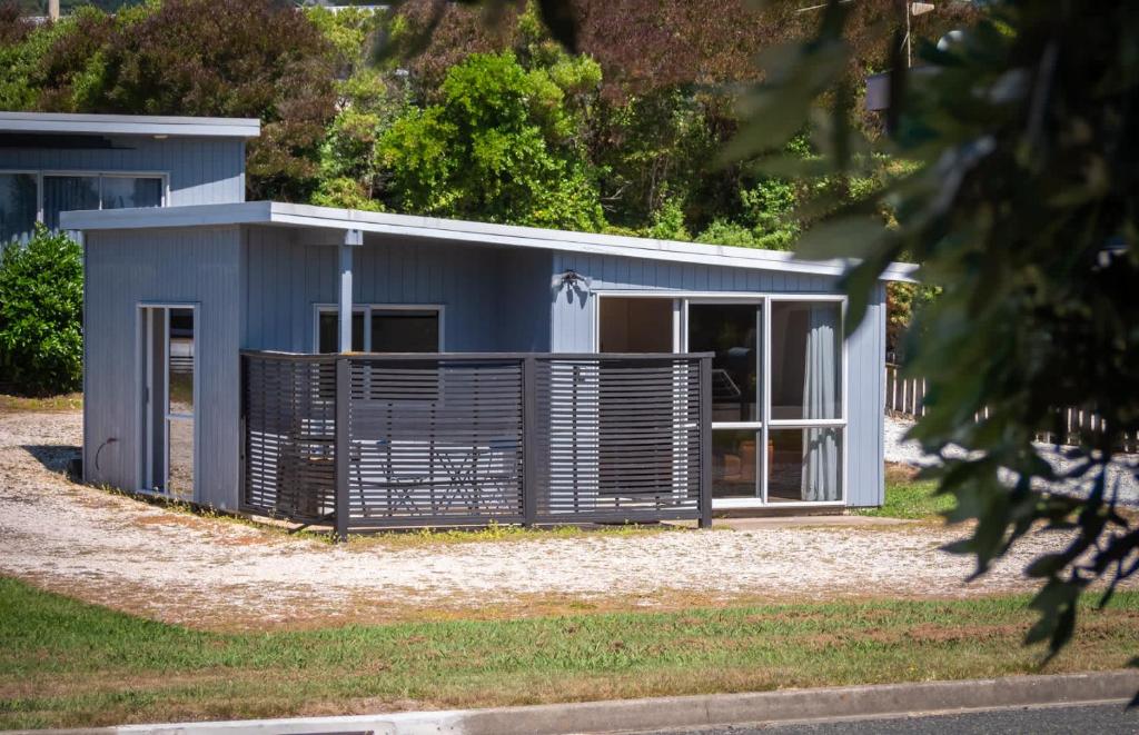 a small blue house with a fence around it at Pohara's Beachside Gem in Pohara