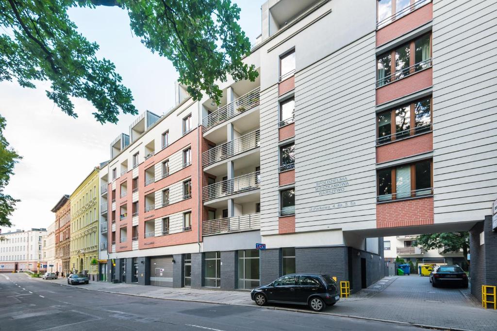 an apartment building with a car parked in front of it at SAS Apartamenty New Park in Szczecin