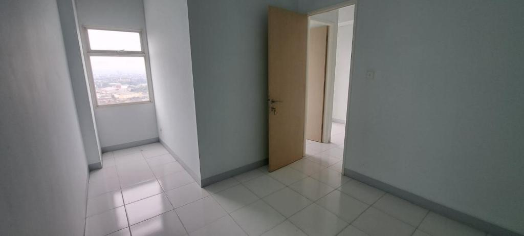 an empty room with a window and a white floor at Apartement ayodhya 2BR Unfurnished in Tjikokol