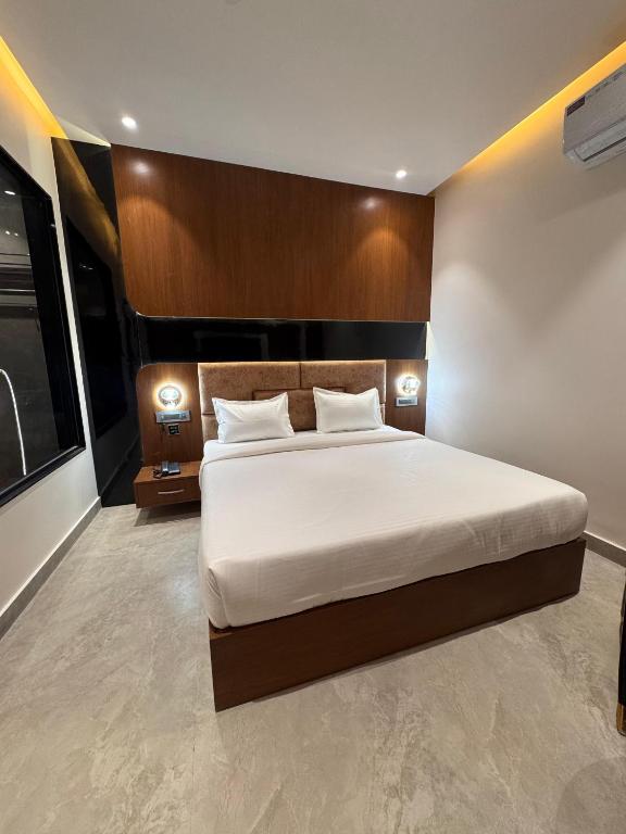 a bedroom with a large bed and two lamps at Hotel M Stayz Sirsa in Sirsa