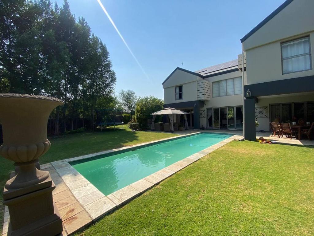 a swimming pool in the yard of a house at Riverfront Golf Estate House in Parys