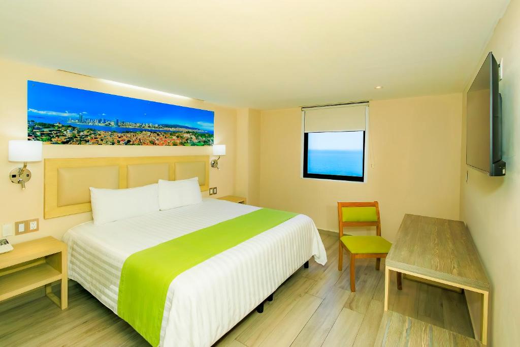 a hotel room with a bed and a desk and a television at Collection O Hotel Paris FC, Veracruz in Veracruz