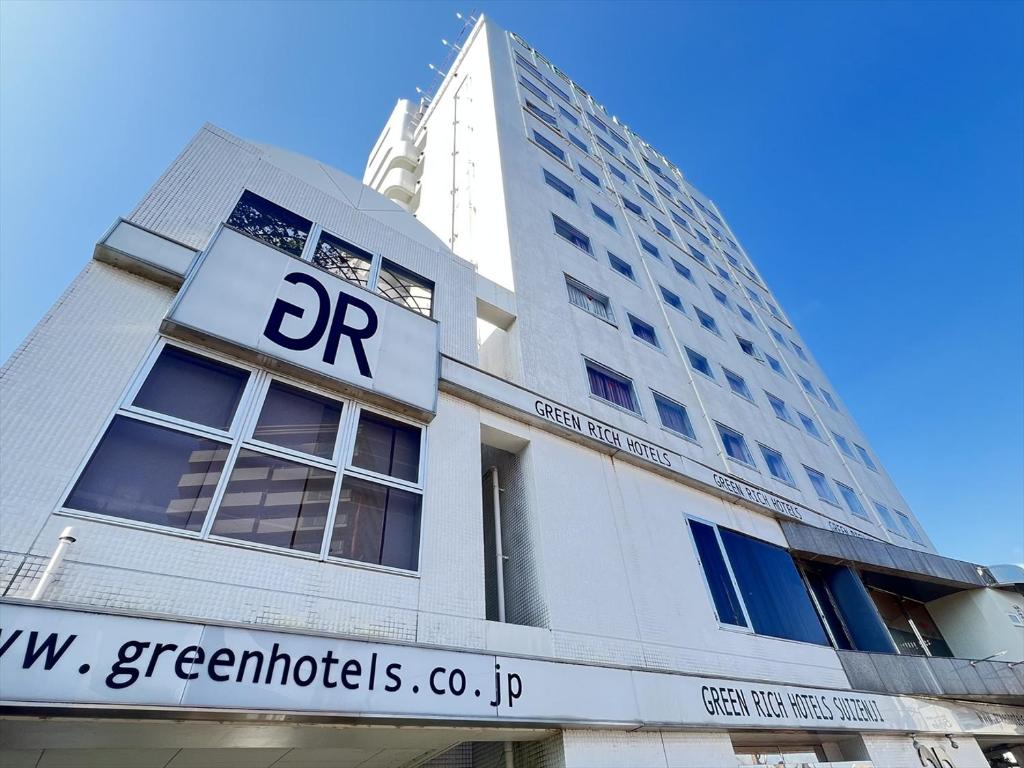 a building with a sign on the front of it at Green Rich Hotel Suizenji in Kumamoto