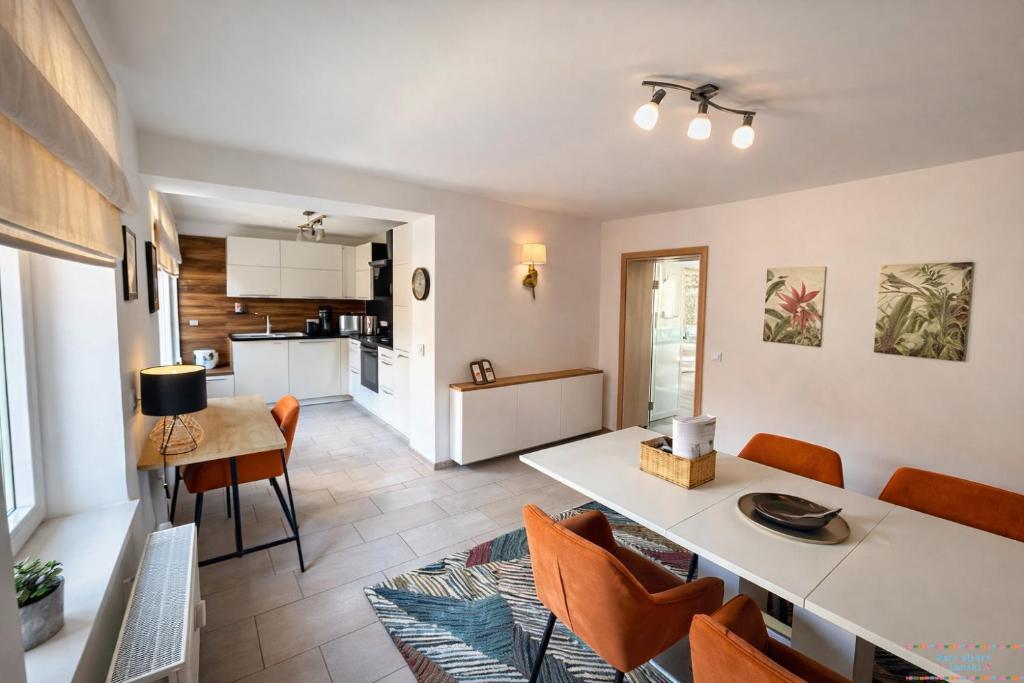 a kitchen and living room with a table and chairs at Hidden Gem Near the Moselle River in Grevenmacher
