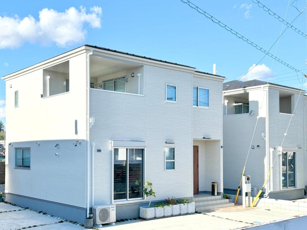 a white house with a lot of windows at The ITO 伊藤 in Abiko