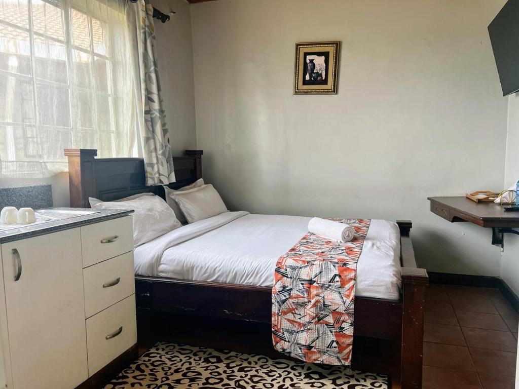 a small bedroom with a bed and a sink at Westbreeze Residences in Nairobi