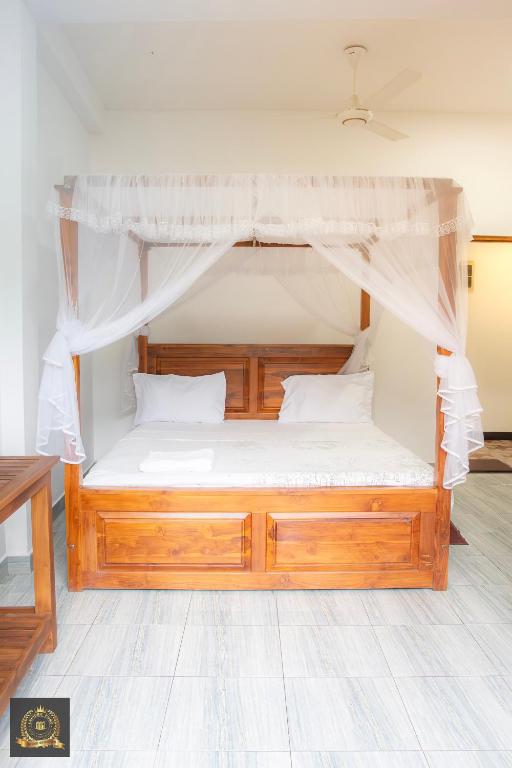 a bedroom with a wooden bed with a canopy at Triple W in Watta