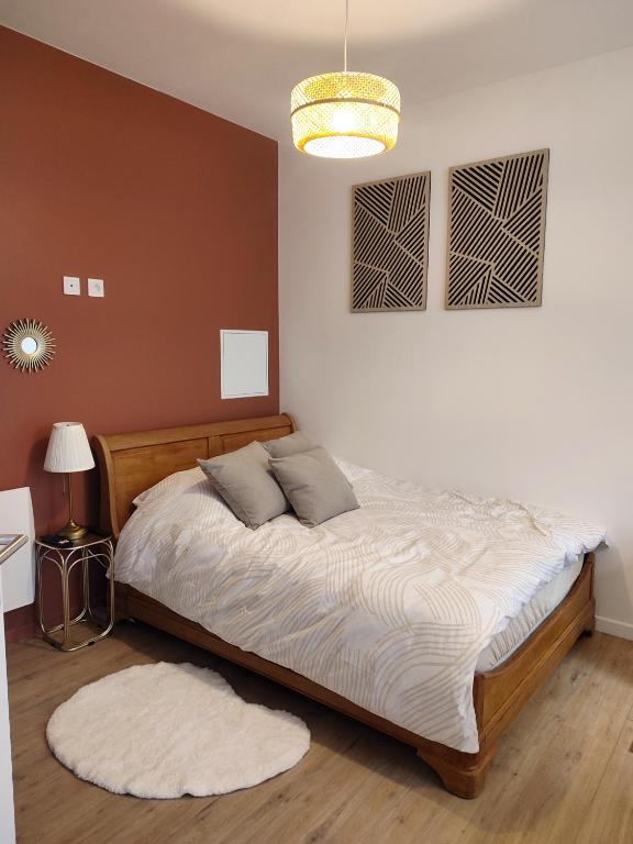 a bedroom with a bed and a chandelier at Le Bohème in Chaumont