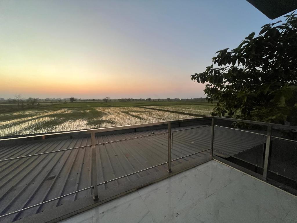 a view from the roof of a house looking at a field at Green Heaven Stay in Surat