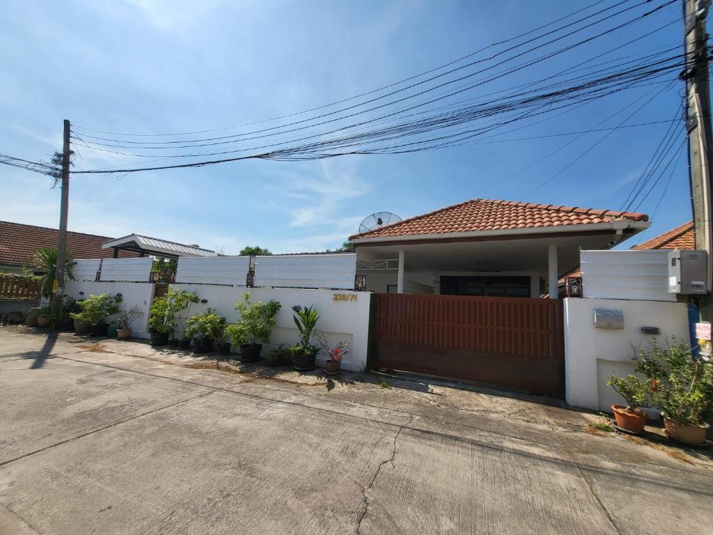 a white fence in front of a house at Baan Khun Pim Pool Villa in Ban Suan Maphrao
