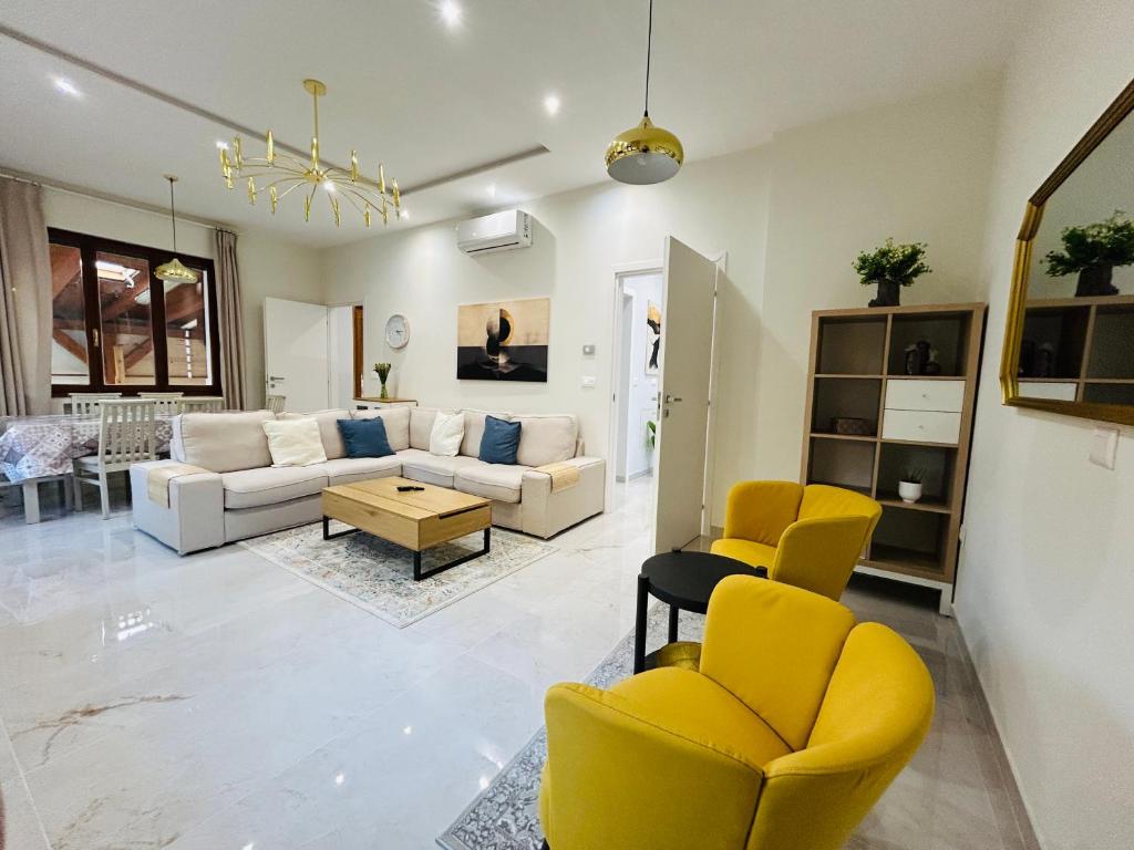 a living room with yellow chairs and a couch at Terme Boutique House in Montegrotto Terme