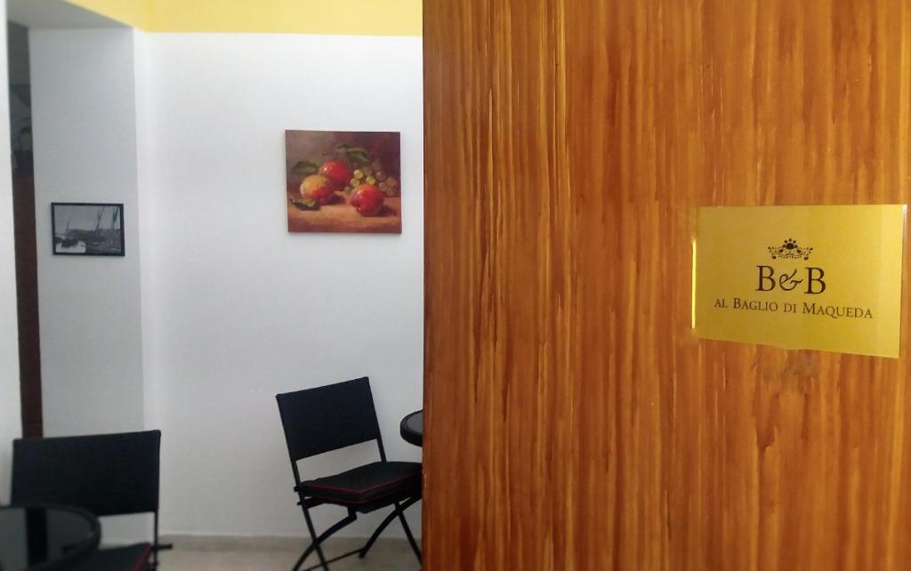 una puerta en una habitación con sillas y una foto de manzanas en Al Baglio di Maqueda, en Palermo