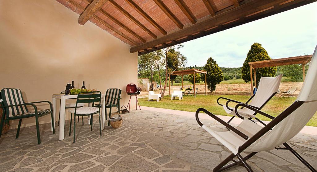 a patio with chairs and a table and a table and chairs at Agriturismo Poggio Agli Ulivi in Riotorto
