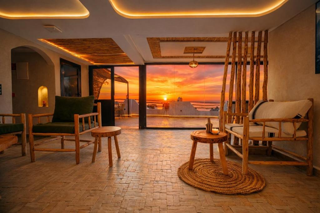 a living room with a view of a sunset at Surf Lodge Tamraght in Tamraght Ouzdar