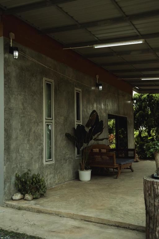 a porch of a house with a potted plant on it at บ้านมนต์รักเชียงดาว in Chiang Dao