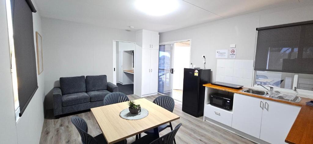 a kitchen and living room with a table and a couch at Drummond Cove Holiday Park in Drummond Cove