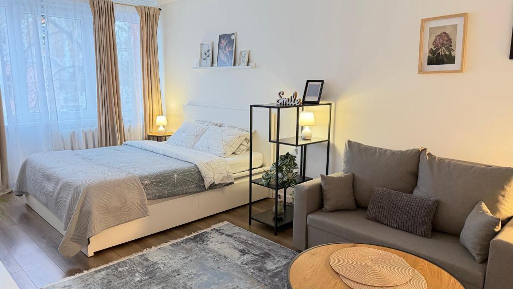 a bedroom with a bed and a couch at Church Hill Apartment in Daugavpils