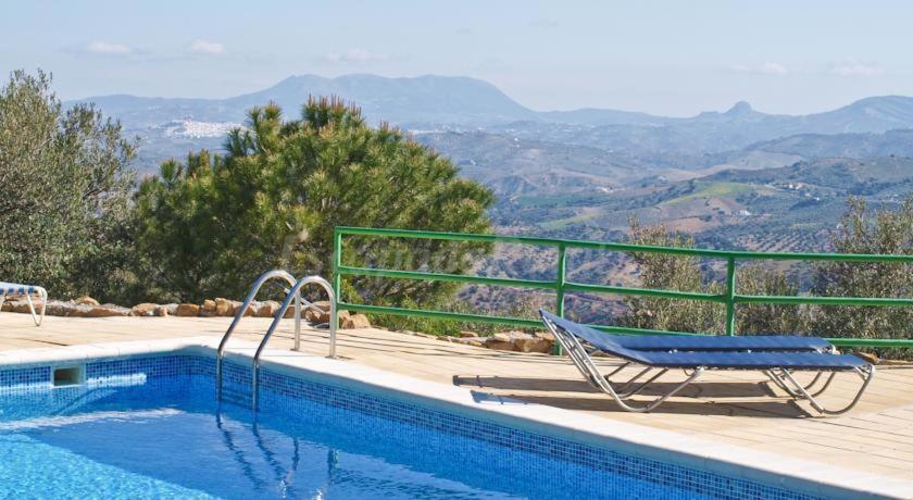 a chair sitting next to a swimming pool with a view at Conjunto El Carramolo in El Gastor