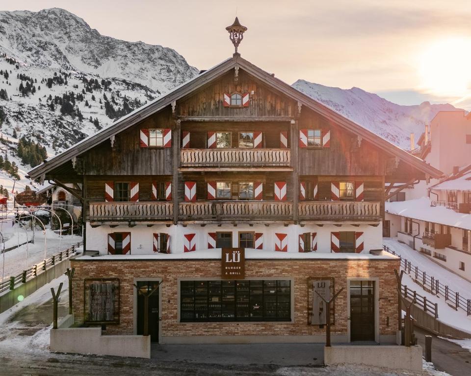 a log cabin in the mountains with snow at Hotel LÜ - Adults Only in Obertauern