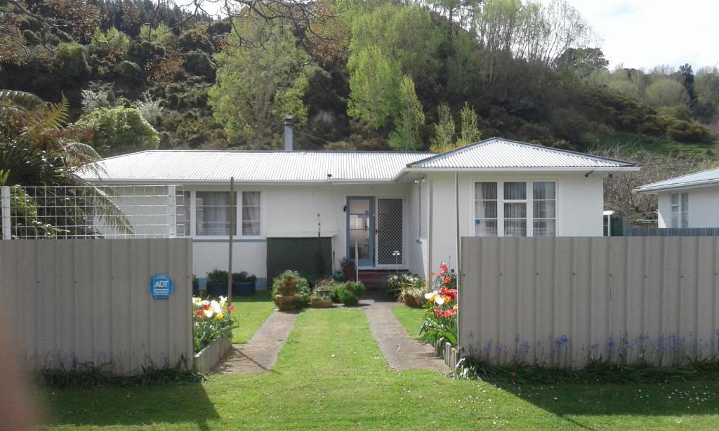 une maison blanche avec une clôture devant elle dans l'établissement The_Cozy_Batch With a rural view, à Whanganui