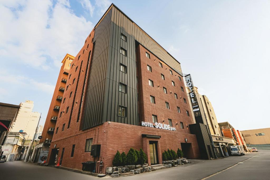 a tall red brick building on a city street at Hotel Solide Cheonan in Cheonan