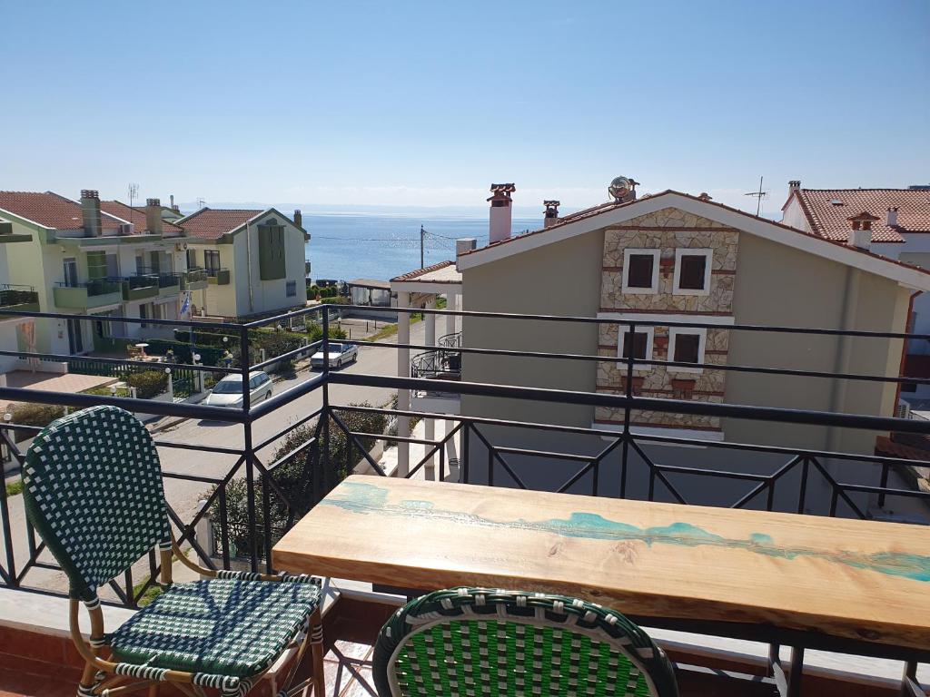 a table and chairs on a balcony with the ocean at Teo`s Seaview Specious Apartment, Nikiti near Harbor in Nikiti