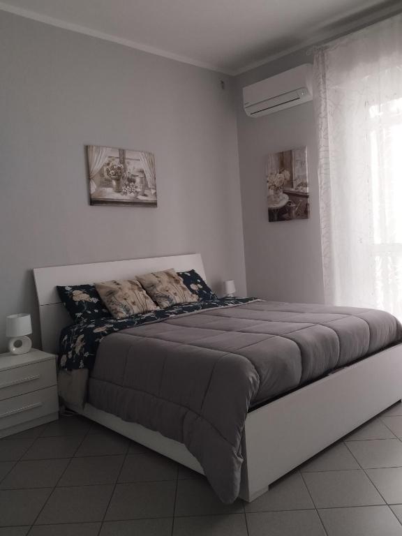 a bedroom with a large bed in a white room at Appartamento Conte Verde in Vercelli