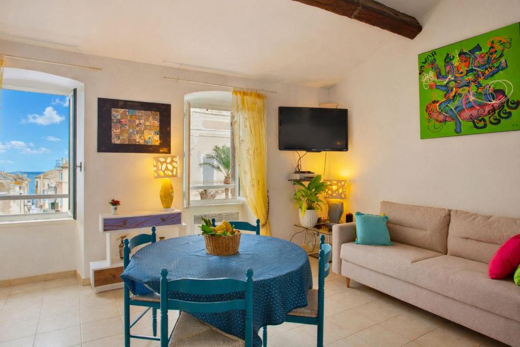a living room with a table and a couch at Casa Erbalunga Au cœur du village proche du port et de la plage in Erbalunga