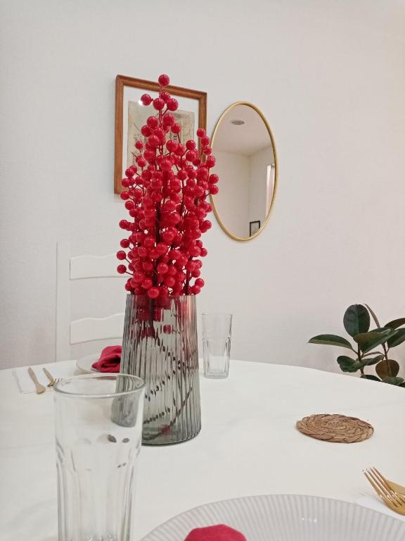 a vase filled with red flowers sitting on a table at Sava & Double Rooms in Prijedor