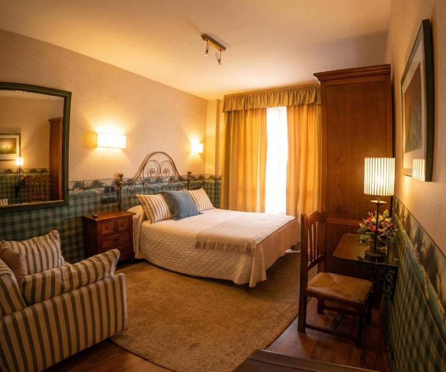 a bedroom with a bed and a window and a couch at Hotel Avenida Real in Villaviciosa
