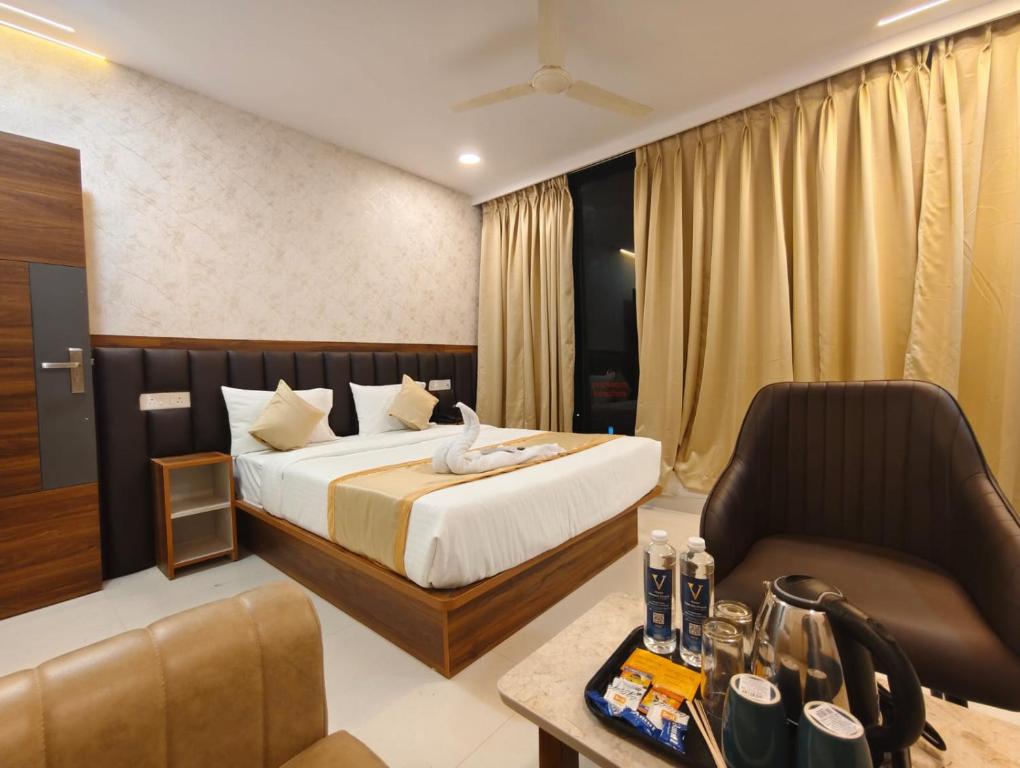 a hotel room with a bed and a chair at Hotel Vamshi Grand in Lingampalli